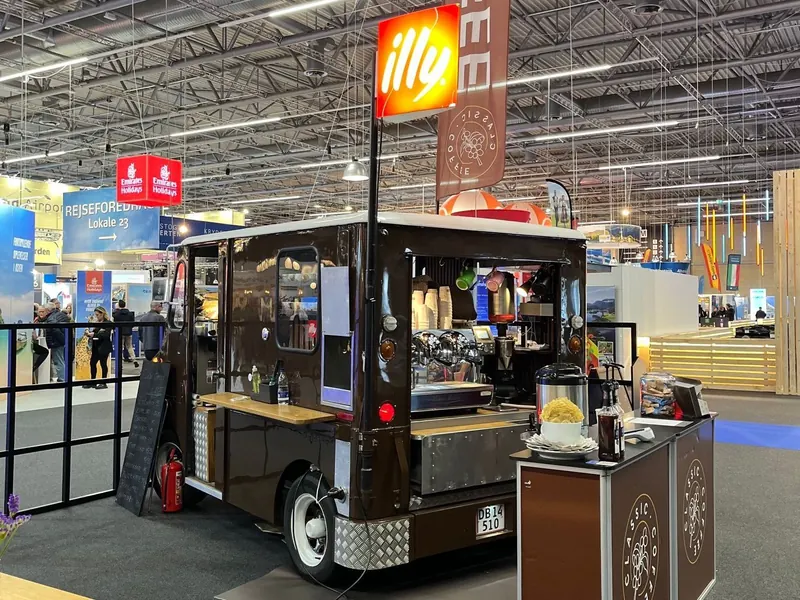 Kaffebilen Queen fra 2019 på en messe, med illy-skilt og Classic Coffee-flag